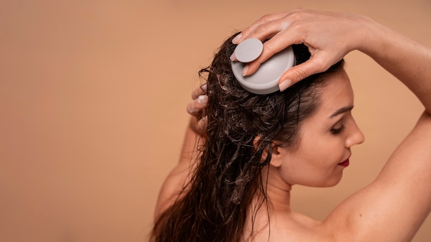 Free photo medium shot woman giving herself scalp massage