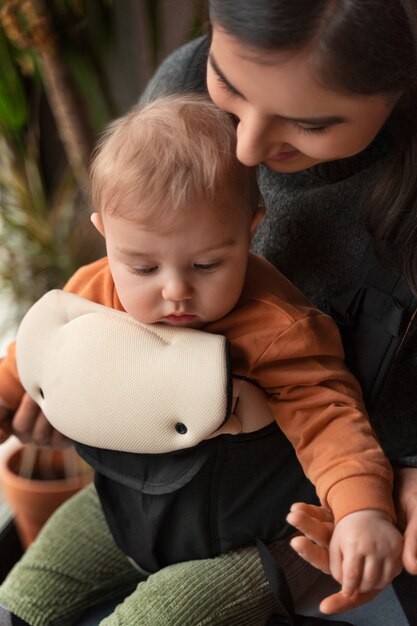 Medium shot woman holding baby in carrier