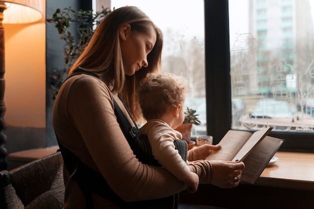 Medium shot woman holding baby in carrier