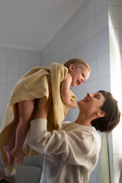 Medium shot woman holding baby up