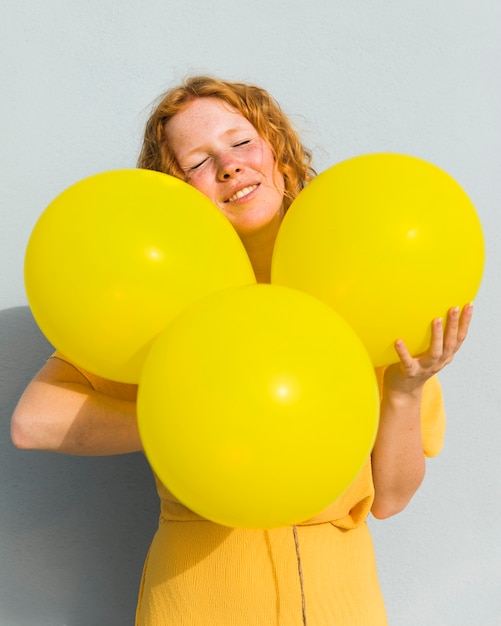 Medium shot woman holding balloons