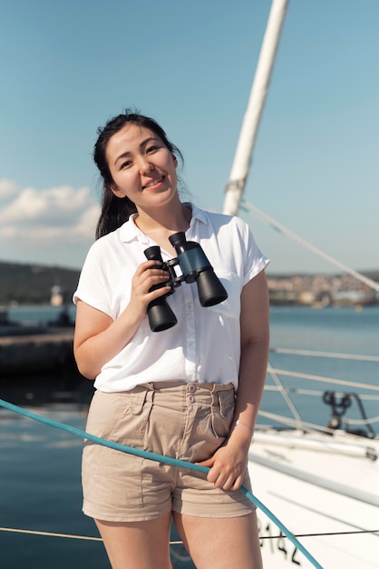 Free photo medium shot woman holding binoculars