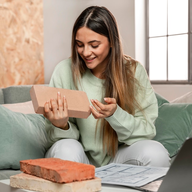 Medium shot woman holding brick