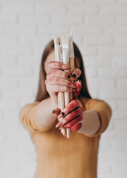 Medium shot woman holding brushes