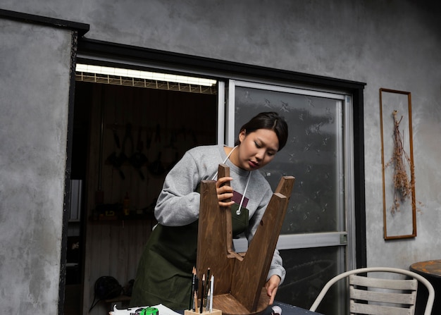 Free Photo medium shot woman holding chair