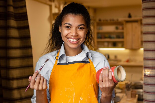 Medium shot woman holding clay pot