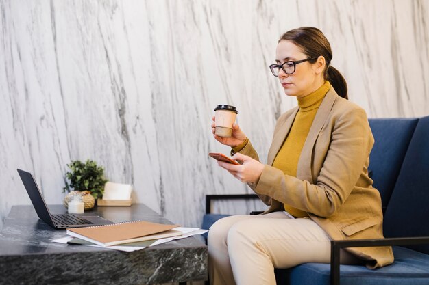 Medium shot woman holding coffee cup