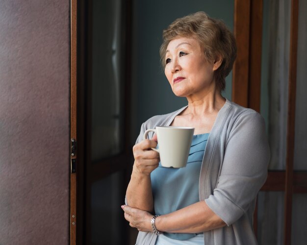 Medium shot woman holding coffee mug