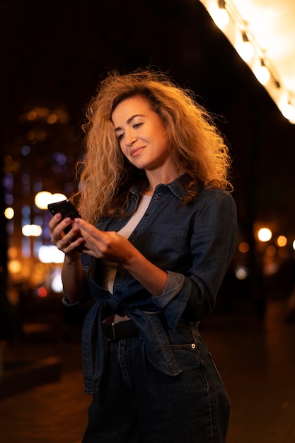 Medium shot woman holding device