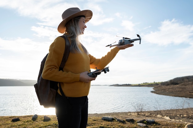 Free photo medium shot woman holding drone outdoors