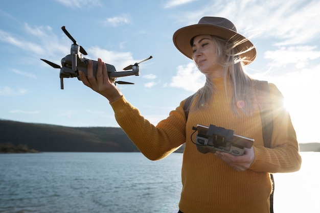 Free Photo medium shot woman holding drone and remote