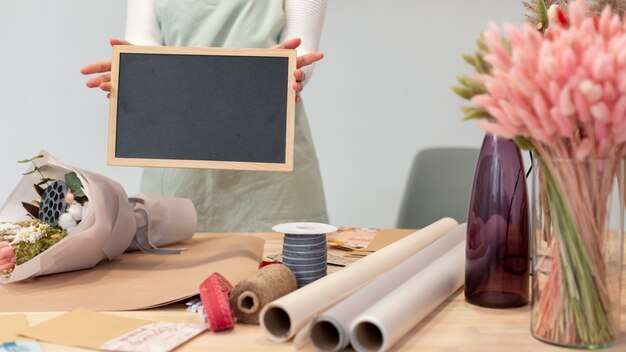 Medium shot woman holding an empty copy space chalkboard