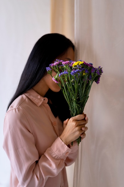 Medium shot woman holding flowers