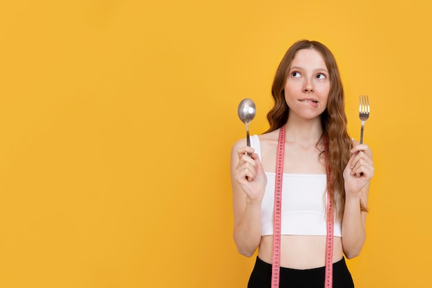 Free Photo medium shot woman holding fork and spoon