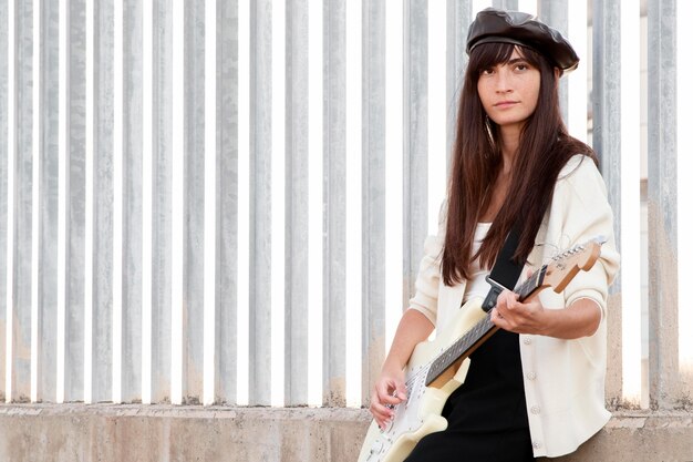 Medium shot woman holding guitar