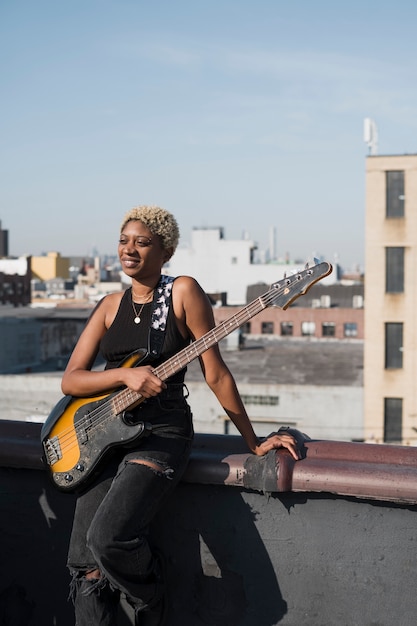 Medium shot woman holding guitar