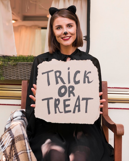 Medium shot woman holding halloween sign