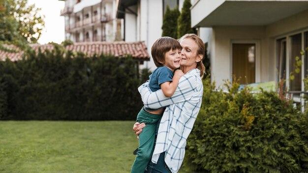 Medium shot woman holding happy kid