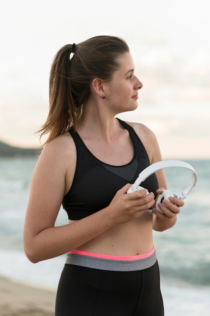 Medium shot woman holding headphones