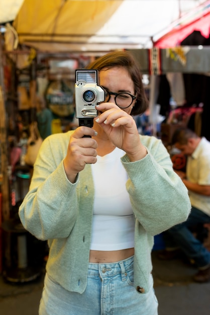 Medium shot woman holding old camera