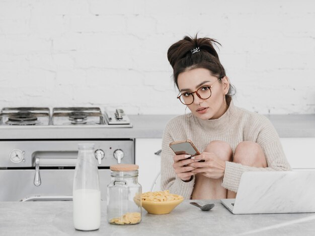 Medium shot woman holding phone