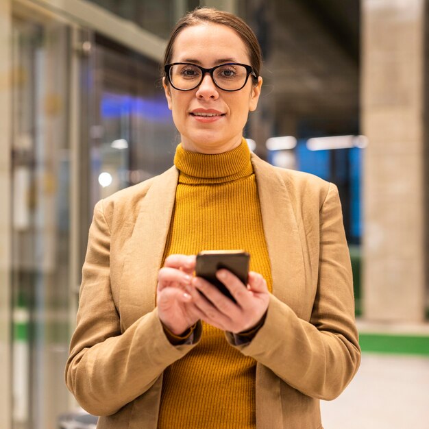 Medium shot woman holding phone