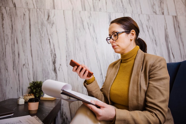 Medium shot woman holding phone