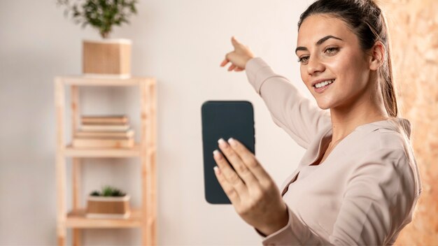 Medium shot woman holding phone