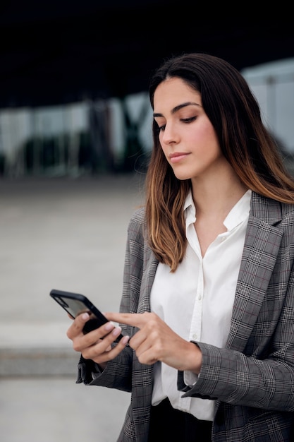 Medium shot woman holding phone