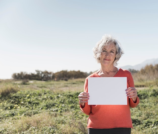 Medium shot woman holding a piece of paper