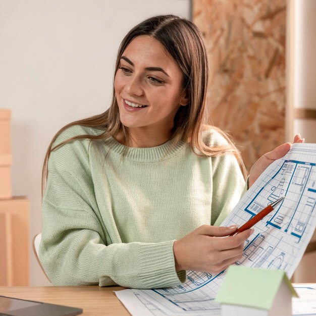 Medium shot woman holding plan