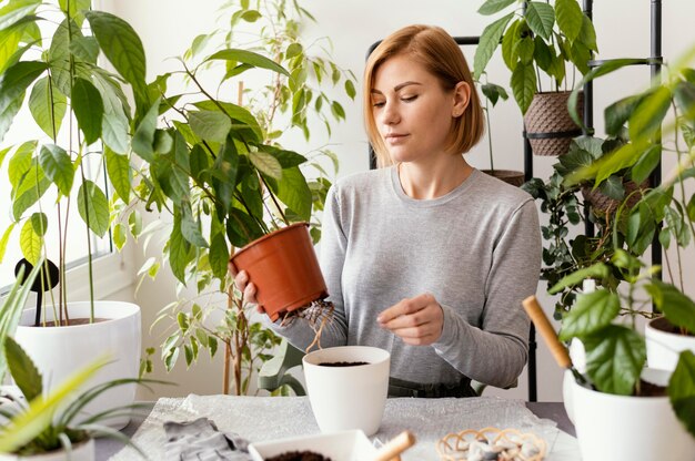 Medium shot woman holding plant pot