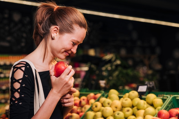 Medium shot woman holding a red apple