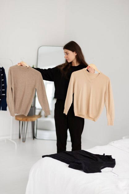 Medium shot woman holding shirts