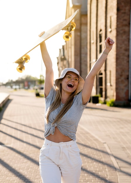 Free photo medium shot woman holding skateboard