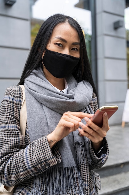 Medium shot woman holding smartphone