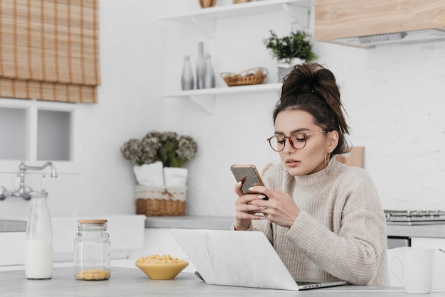 Medium shot woman holding smartphone