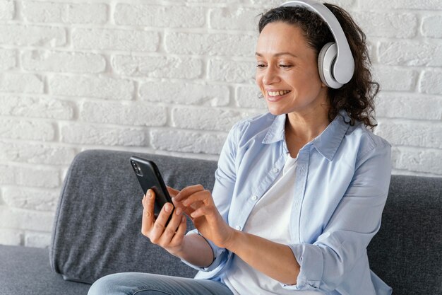 Medium shot woman holding smartphone