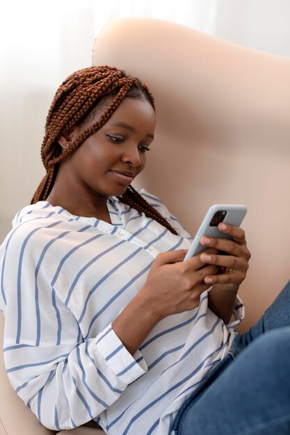 Medium shot woman holding smartphone