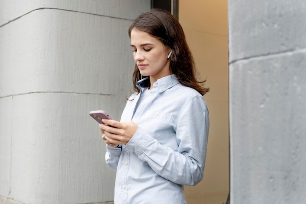 Medium shot woman holding smartphone