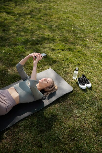 Medium shot woman holding smartphone