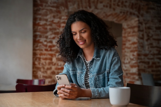 Medium shot woman holding smartphone