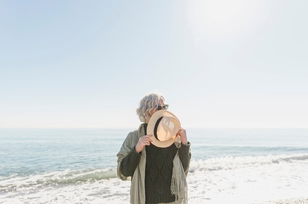 Medium shot woman holding straw hat