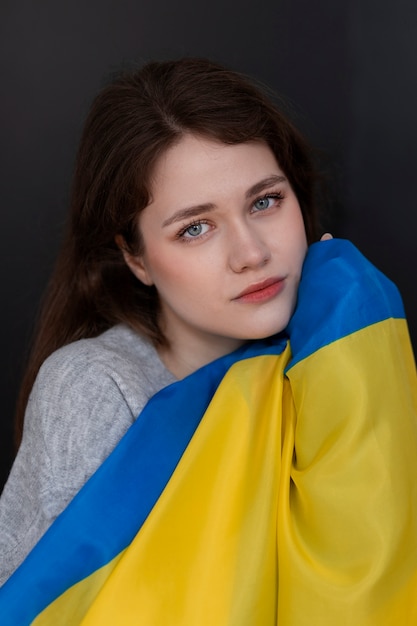 Free Photo medium shot woman holding ukrainian flag