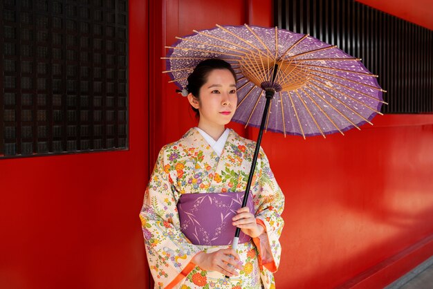 Medium shot woman holding wagasa umbrella