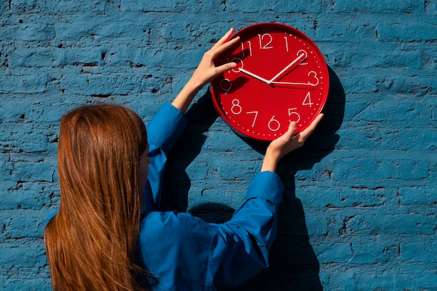 Free photo medium shot woman holding wall clock