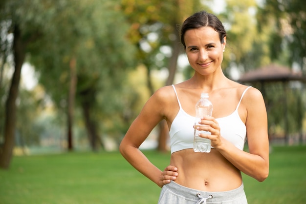 Medium shot woman holding water bottle