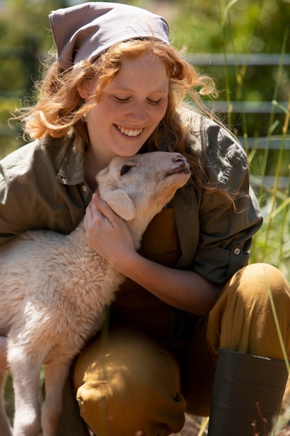 Free photo medium shot woman hugging lamb