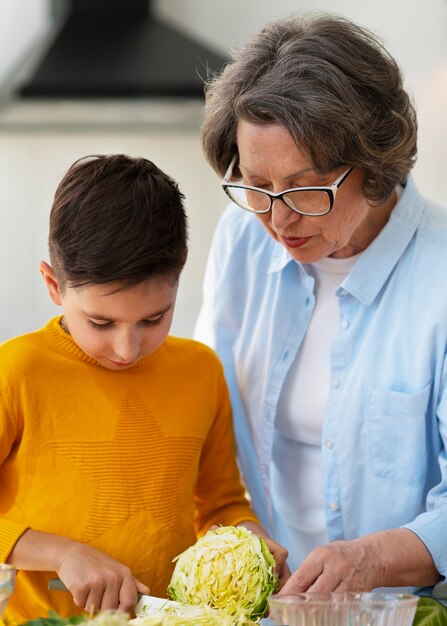 Medium shot woman and kid cooking together