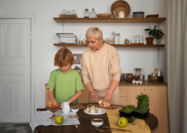 Free photo medium shot woman and kid preparing food